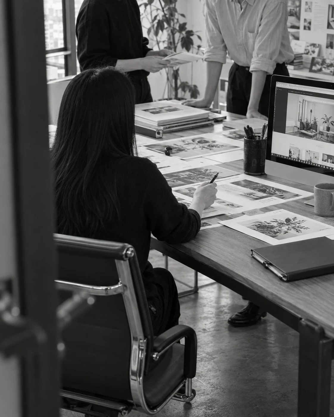 Illustrative black-and-white scene of a team reviewing work together